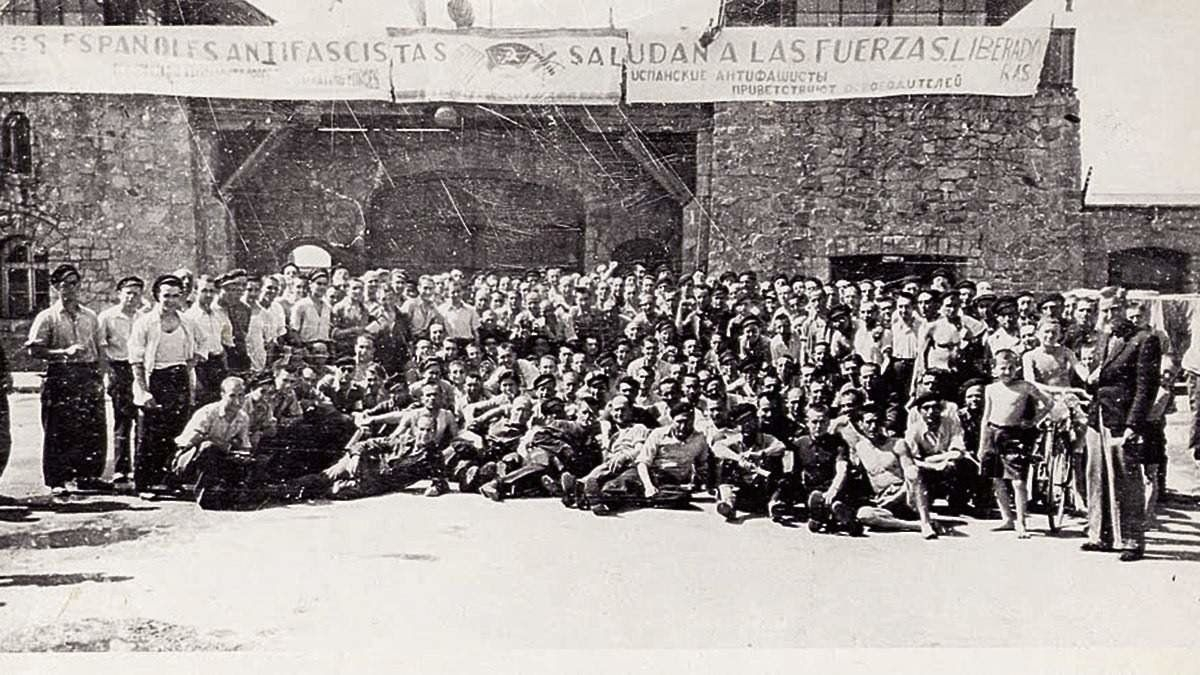 Los deportados españoles junto a la pancarta de bienvenida a las tropas aliadas tras la liberación del campo//Imahen: Asociación para la Recuperación de la Memoria Histórica.