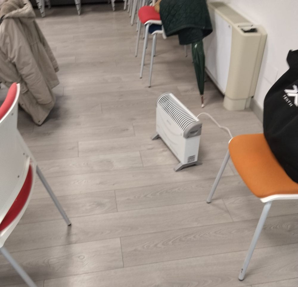 En la clase de costura, con calefactor y el abrigo cerca.