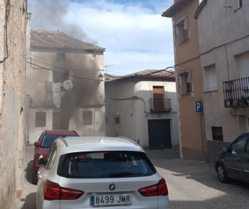 Los bomberos trabajan en la extinción de un incendio en una casa del casco antiguo de Horche